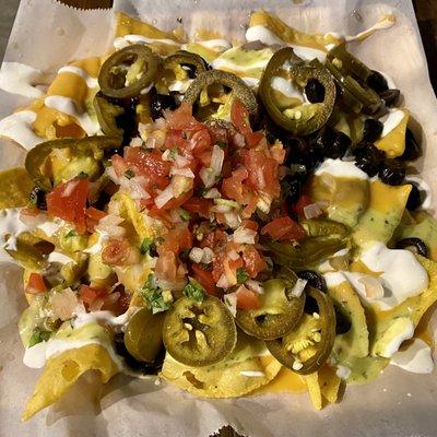 Nachos ($10.95) with cheese sauce, beans, pico de gallo, olives, sour cream, jalapenos, and guacamole sauce on tortilla chips