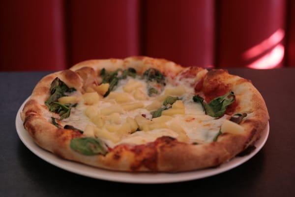 Cheese pizza with pineapple and spinach.