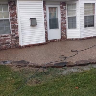 Exposed agragate patio with native stone border.