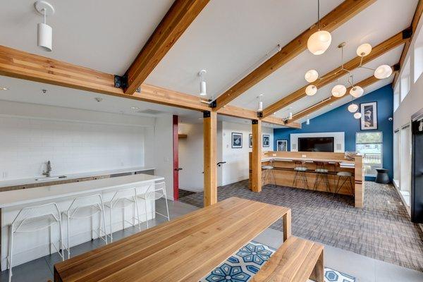 Clubhouse with bar seating, exposed beams, tables and chairs