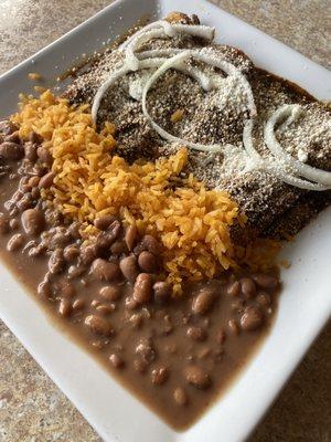 Mole Enchiladas:  Corn tortilla with chicken in a rich mole sauce, topped with cheese and red onions, served with rice and beans.