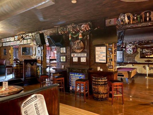 Seating around the middle dividing wall of pig's eye, pool tables and bar to right