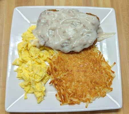 Country fried steak with eggs & hash browns.