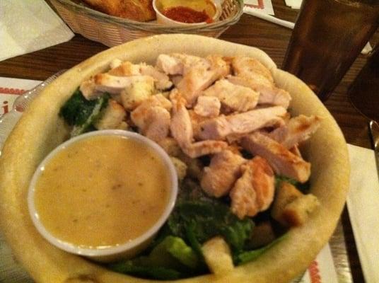 Grilled chicken caesar salad in a bread bowl