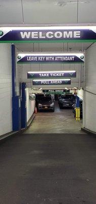 Inside Centerpark West 17th Street Garage, clear signs guide drivers to leave keys, take a ticket, and pull ahead for efficient parking.