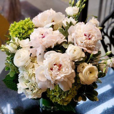 White and green lush arrangement with peonies, hydrangea and ranunculus.