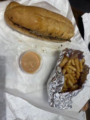 Philly Cheesesteak with onions, peppers and provolone, fries and fry sauce.