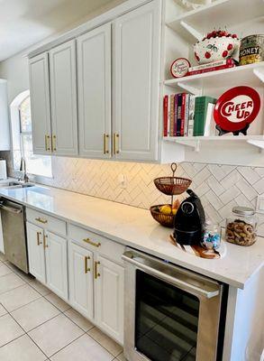 kitchen with new quartz countertops, backsplash, sink, cabinet for wine fridge, and freshly painted cabinets