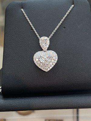 Heart shape necklace with round and baguette diamonds.