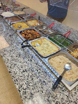 Bottom left to right: White rice, beans, spaghetti, stewed pork, chicken lasagna, couscous.  Top: brown rice with veggies, sausage