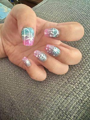 Short semi-coffin nails with acrylic blue to pink sparkly ombre and galaxy star gel design