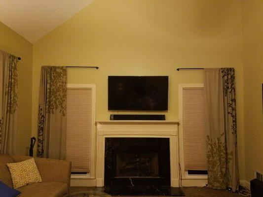 55" Smart LED mounted above fireplace with wireless soundbar.