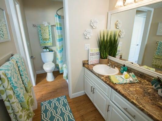 Updated bathrooms featuring large mirrors and granite-style countertops.