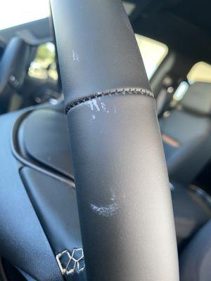 Paint on the left side of the steering wheel.