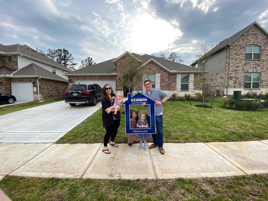 A family in front of their new home