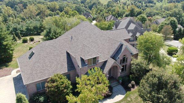 Aerial photo of a brick house with a new roof.