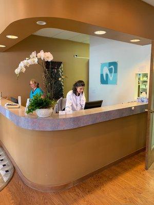 Reception desk at Newbury Dental in Oakmore, Oakland; Dr. Askari in photo.