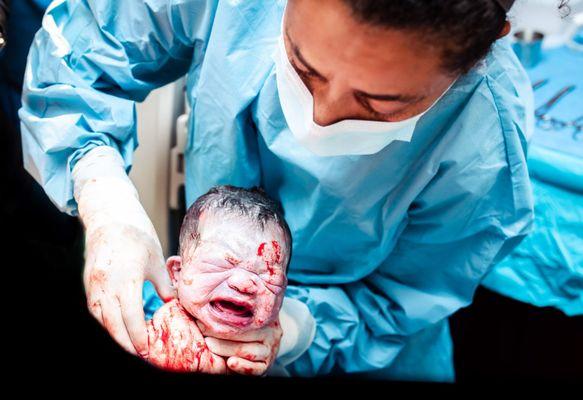 Dr. Daif Parker delivering newborn baby girl for first time parents at Boca Regional Hospital