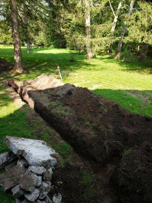 Excavating a trench from the home to the septic tank