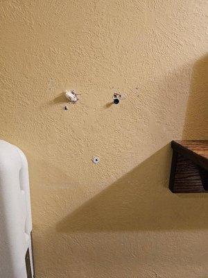 Holes left unrepaired, screw, toilet paper stuffed into one hole