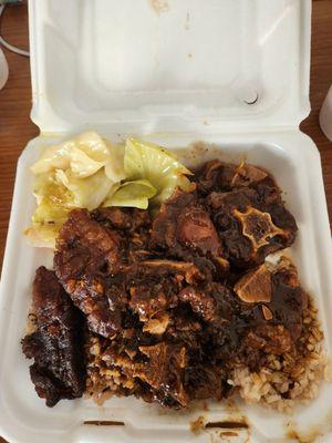 Oxtails cabbage peas and rices and plantains.