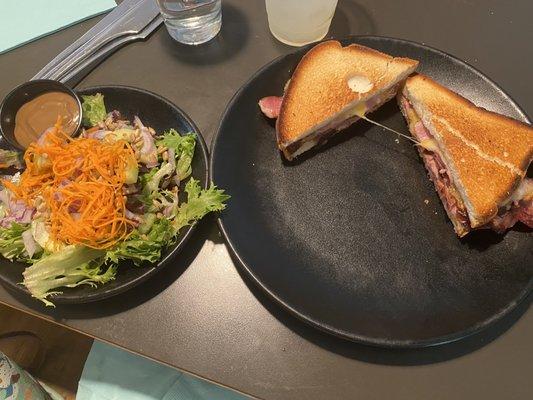 GF grilled ham and cheese sandwich with a salad.