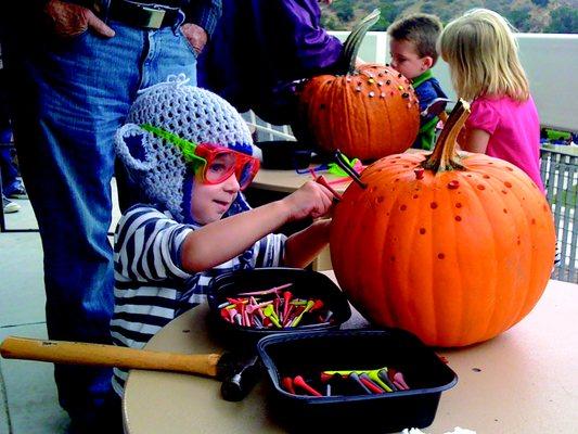 young boy carves a pumpkin at MC-CDC