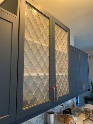 Decorative cabinet glass inserts using traditional design with frosted glass and copper metal finish