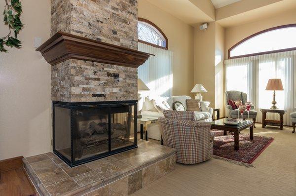 Patterned carpet and stacked stone fireplace