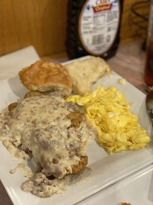 Country fried steak with scrambled eggs and biscuit