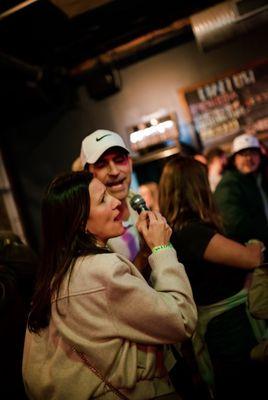 Friends having fun singing along at karaoke bar