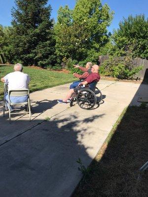 Enjoying the sunshine and warm weather in the backyard at Aspen Meadows Care Home By RNs (faces are intentionally obscured for privacy).