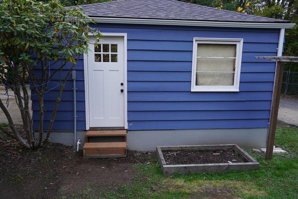 We installed new garage doors custom made by us, New stairs, New door, and all of the gray skirting around the buildings.