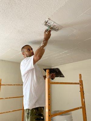 Skim coating to smooth over popcorn ceilings.