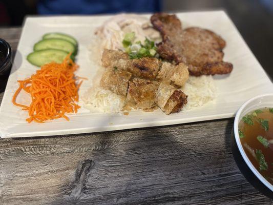 Rice dish with pork chop, chicken, and egg rolls