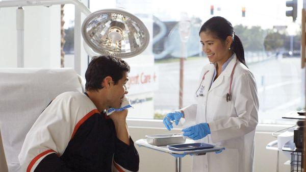 Nurse Practitioner, Ireena Wang, preparing to suture facial laceration of hockey player.