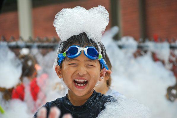 Kid having fun at the Godine bubble party.