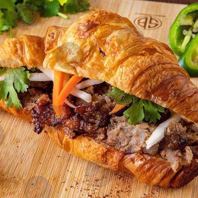 Croissant Grilled Pork Sandwich. Pork barbecue marinated in a sweet sauce served in a fresh baked croissant with a sugar glaze.