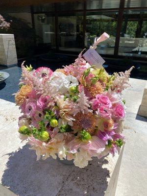 Pink arrangement with roses, peonies, astilbe, dahlias, mums, and ranunculus.