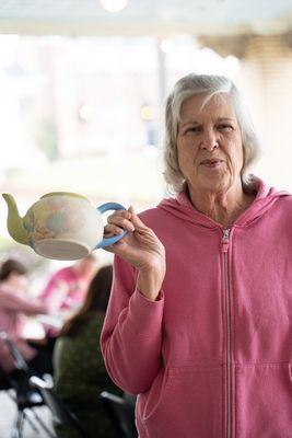 People painting pottery at the cupboard