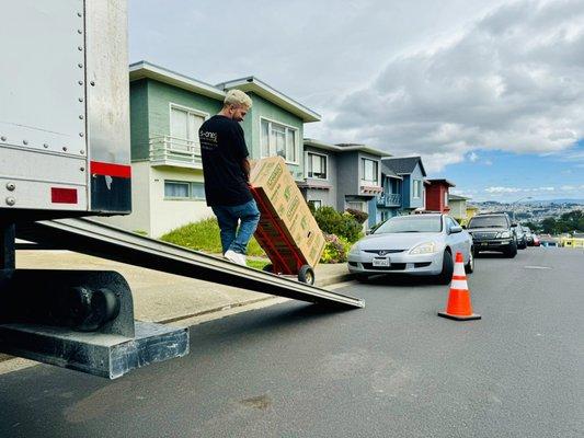 A mover is unloading items from the truck, efficiently transferring them to their destination.