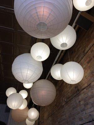 Lanterns fill the tall ceiling and creates a warm environment. The floor space is extremely limited and the seating is shared.