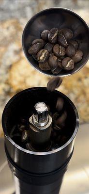 Pouring the beans into grinder for a pour over.