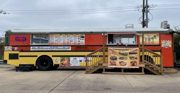 The food truck (bus) exterior, facing the liquor store parking lot