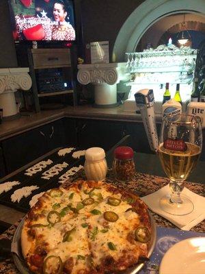 Sausage pizza with green peppers, onions, and jalapeños! With a Stella Artois at the bar!