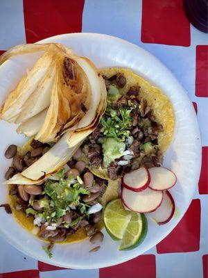 Fresh off the charcoals carne asada tacos, one with beans and one without - had to grab one of their grilled onions as a side munch