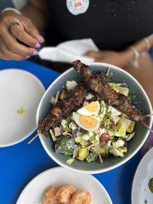 Caesar salad with jerk chicken skewers