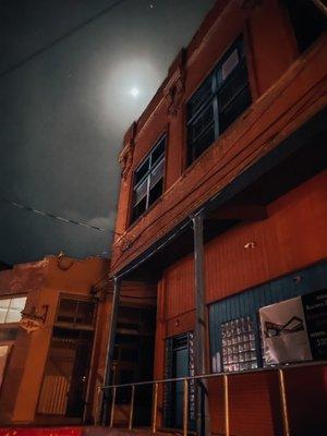 Darkened building with the moon right behind it