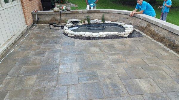 New patio incorporating a pond and seating wall.