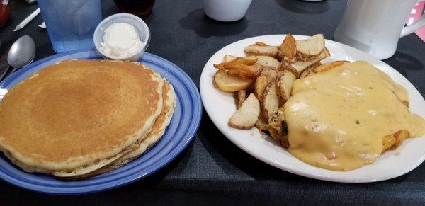 Veggie omlett smothered in vegetarian chili queso with home fries and pancakes